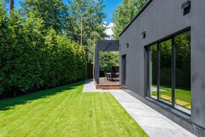 A real contemporary home exterior with dark cladding and large windows.